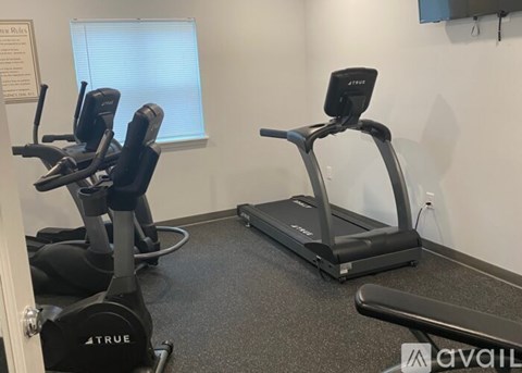 A gym room with a treadmill and a stationary bike.