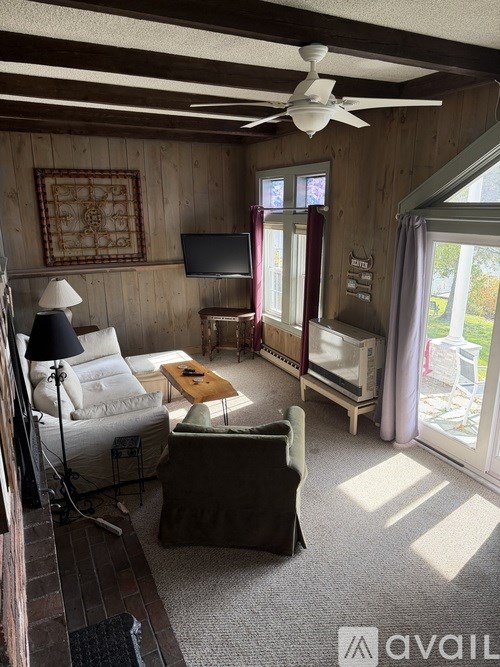 A living room with a couch, chair, and television.