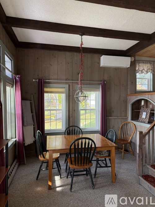 A dining room with a wooden table and chairs.