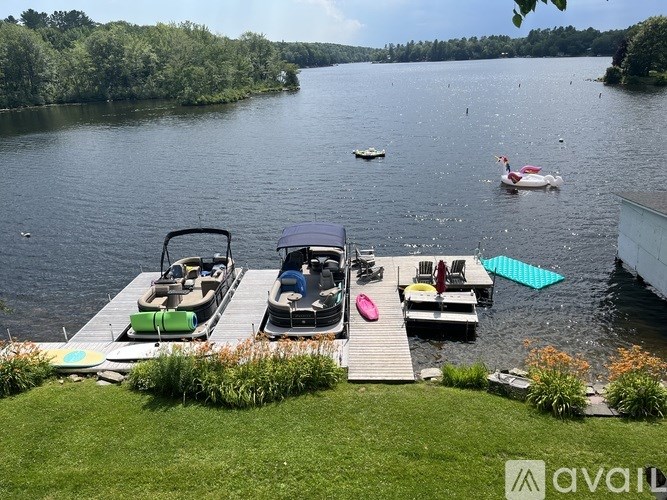 A dock with a grill and seating area overlooks a lake.