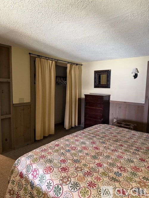 A bedroom with a bed, dresser, and mirror.