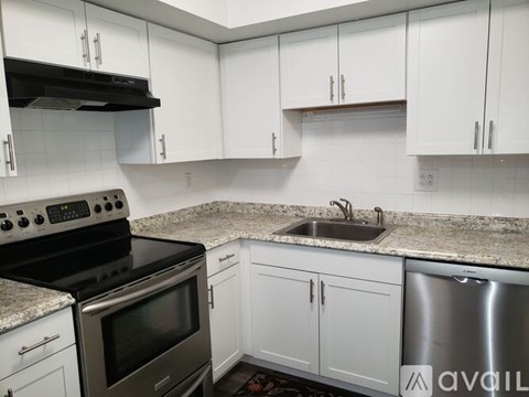A kitchen with white cabinets and a granite countertop.