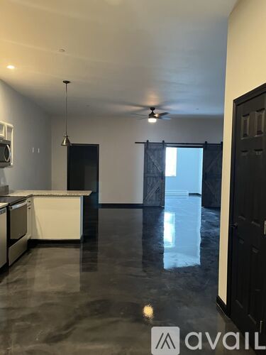 A spacious kitchen with a marble floor and a ceiling fan.
