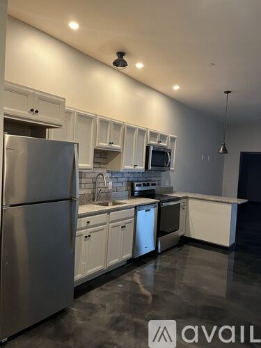 A modern kitchen with stainless steel appliances and white cabinets.