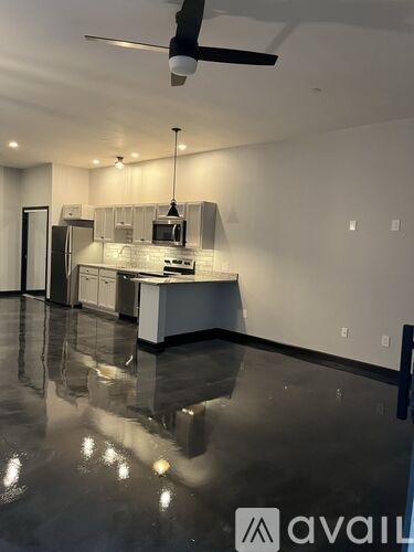 A modern kitchen with a black floor and white walls.