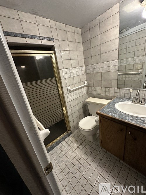 A bathroom with a toilet, sink, and a shower with a glass door.