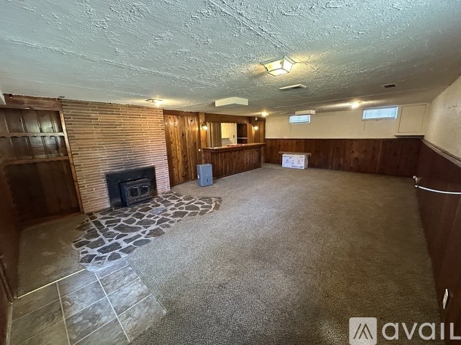 A living room with a fireplace and a stone floor.