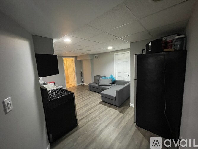 A living room with a black TV and grey couch.