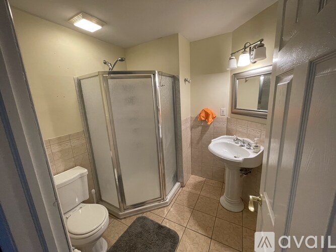A bathroom with a toilet, sink, and shower.
