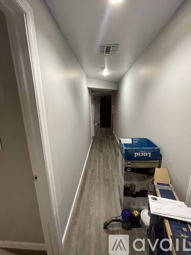 A long hallway with boxes and items on the floor.