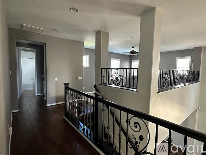 A balcony with a black railing and a spiral staircase.