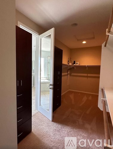 A room with a carpeted floor and a white door.