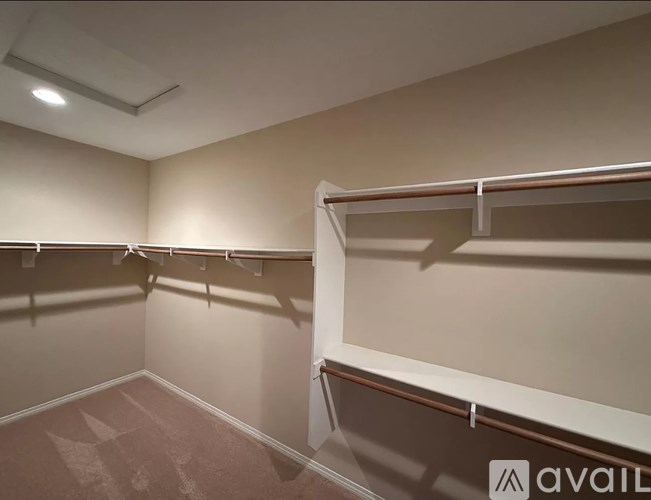 A room with a carpeted floor and a wall-mounted shelf.