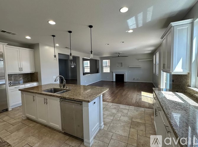 A kitchen with a granite countertop and white cabinets.