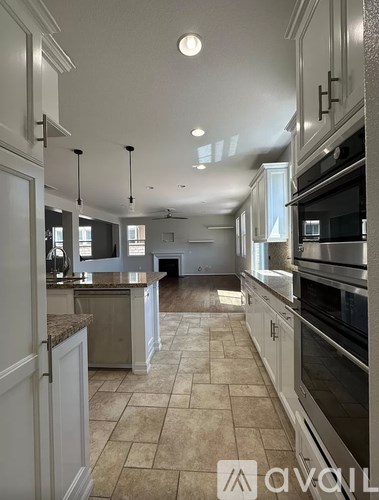 A kitchen with white cabinets and a tile floor.