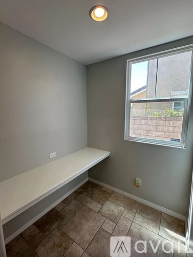 A room with a window and a bench.