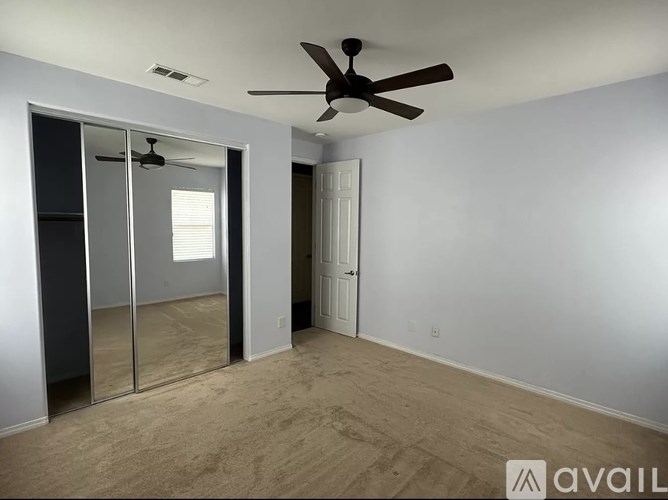 A room with a ceiling fan and a sliding glass door.
