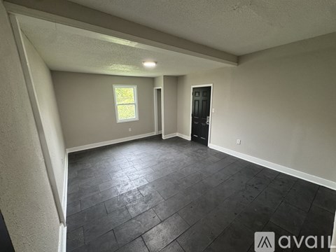 A room with a window and a door is available for rent.