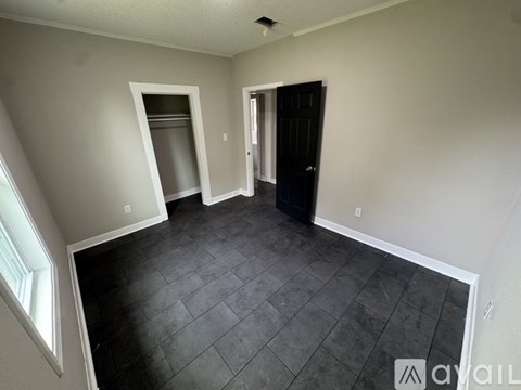 A room with a black door and a window.