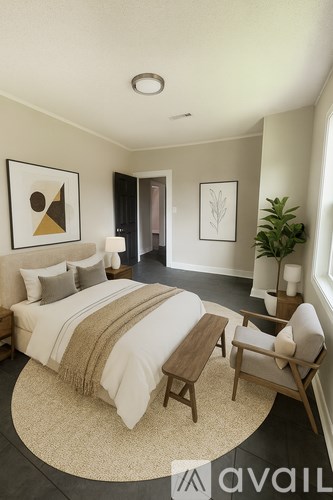 A bedroom with a bed, chair, and two pictures on the wall.