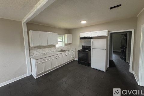 A kitchen with white cabinets and a black stove top oven.