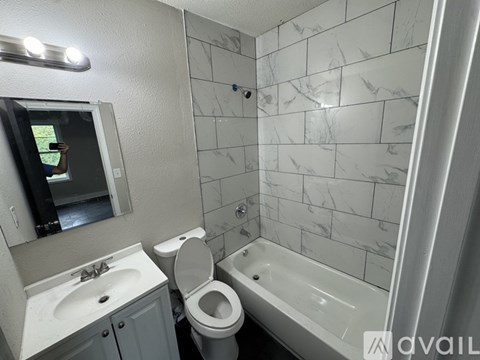 A bathroom with a white sink, toilet, and bathtub.
