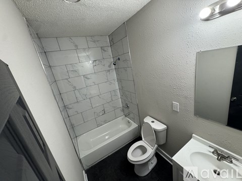 A bathroom with a toilet, sink, and a shower with a glass door.