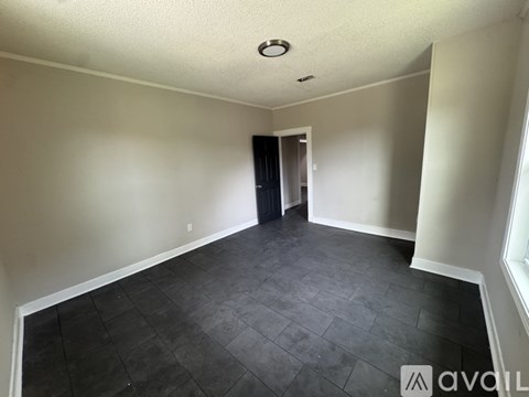 A room with a black door and a tiled floor.