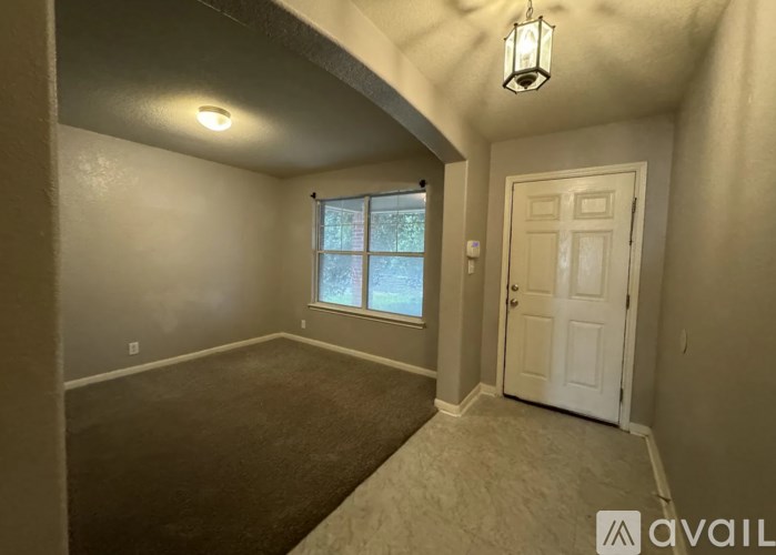 A room with a window and a door is available for rent.