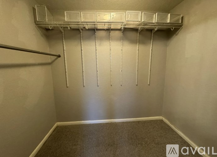A room with a metal shelf and hooks on the wall.