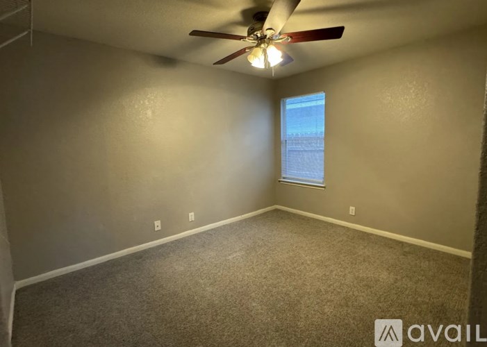 A room with a ceiling fan and a window.