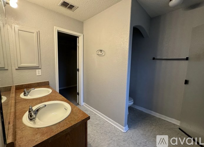 A bathroom with two sinks and a toilet in the corner.