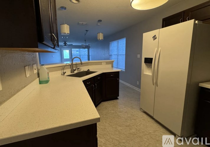 A kitchen with a white countertop and a white refrigerator.