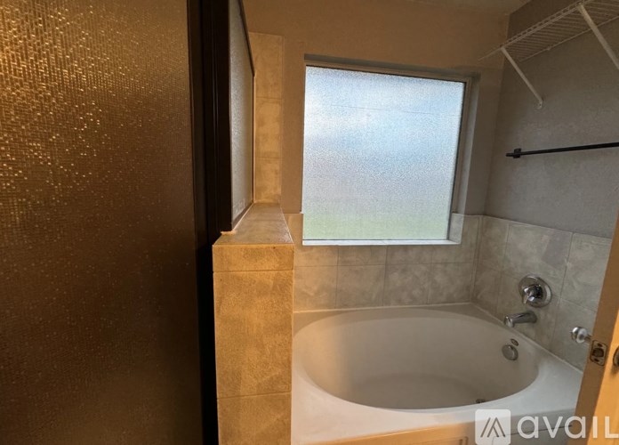 A bathroom with a tub and a window.