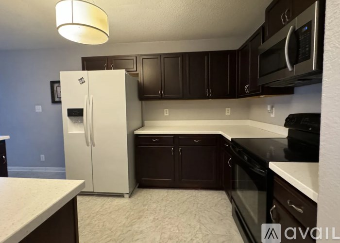 A kitchen with a white fridge and black appliances.