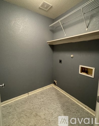 A room with grey walls and a small window.