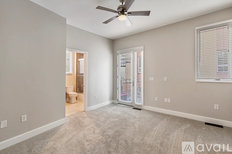 A spacious room with a ceiling fan and a carpeted floor.