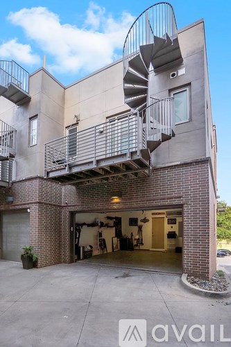 A modern house with a spiral staircase attached to the exterior.