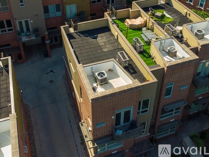 An aerial view of a multi-story apartment complex with a green lawn and patio area.