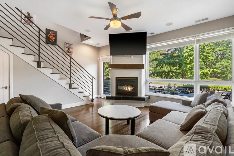 A living room with a fireplace and a staircase.