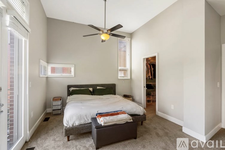 A bedroom with a bed, nightstand, and a ceiling fan.