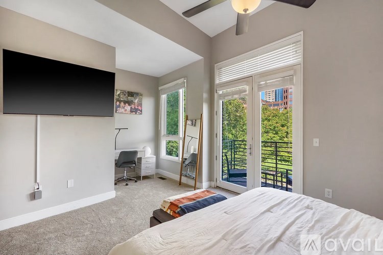 A bedroom with a large bed and a flat screen TV mounted on the wall.
