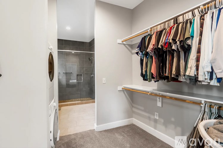 A laundry room with a washer and dryer and a walk in closet.
