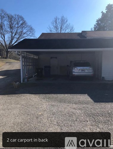 A carport with two cars parked in it.