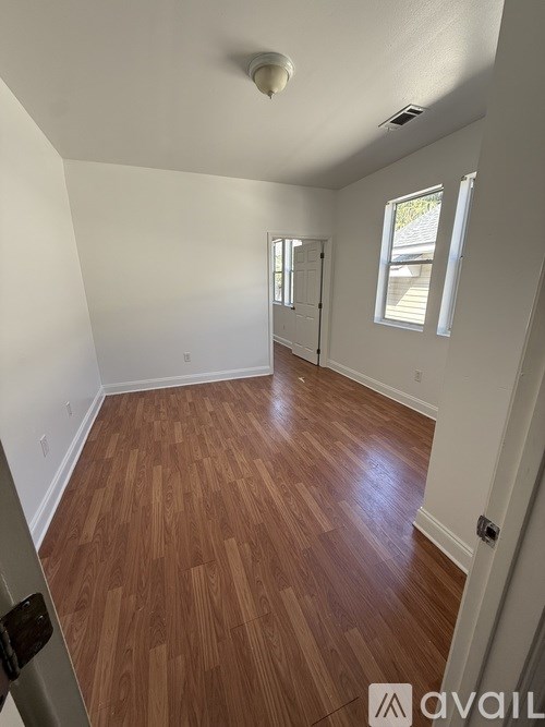 A room with wooden flooring and white walls.