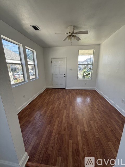 A room with wooden flooring and white walls.