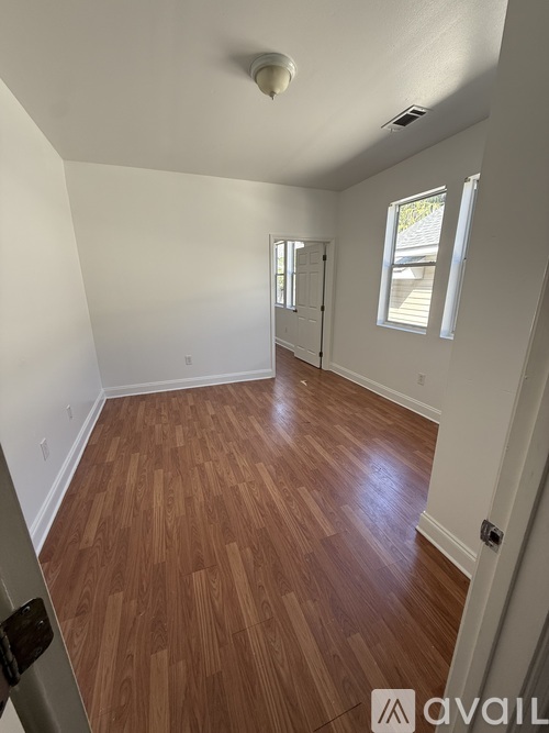 A room with wooden flooring and a ceiling fan.