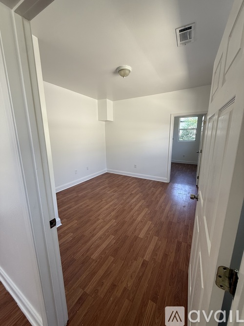 A room with a wooden floor and a ceiling fan.