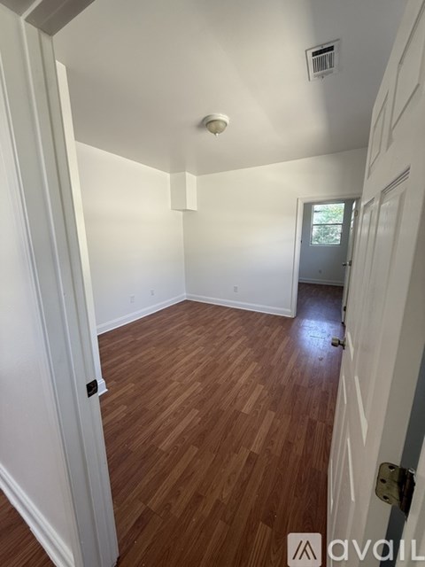 A room with a wooden floor and a ceiling fan.