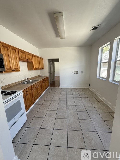 A kitchen with white appliances and wooden cabinets.